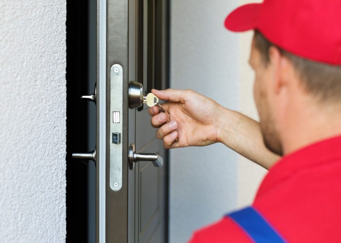 door lock service locksmith working in red uniform